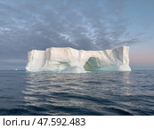 A huge high breakaway glacier drifts in the southern ocean off the coast of Antarctica at sunset, the Antarctic Peninsula, the Southern Arctic Circle, azure water, cloudy weather. Стоковое фото, фотограф Vladimir Drozdin / Фотобанк Лори