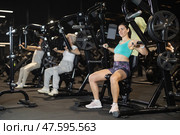 Young woman performing chest press on machine at gym. Стоковое фото, фотограф Яков Филимонов / Фотобанк Лори