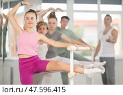 Teenage girl practicing leg stretching exercise during ballet classes. Стоковое фото, фотограф Яков Филимонов / Фотобанк Лори