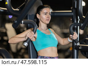 Young woman performing chest press on machine at gym. Стоковое фото, фотограф Яков Филимонов / Фотобанк Лори