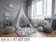 Cozy gray children's playroom with teepee and soft furnishings. Уютная серая детская игровая комната, спальня с вигвамом и мягкой мебелью. Стоковое AI-изображение, AI-художник Katsiaryna Repich / Фотобанк Лори
