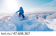 Winter's fort conquest: Child atop a snow battlement. Стоковое AI-изображение, AI-художник Данила Большаков / Фотобанк Лори