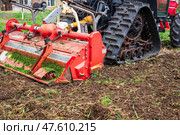Close-up of a tracked tractor with a mounted cultivator working on agricultural land. Soil cultivation, agricultural technology. Стоковое фото, фотограф Коханова Наталья / Фотобанк Лори