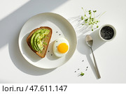 Minimalist breakfast with avocado toast and a perfectly cooked egg. Минималистский завтрак с тостом из авокадо и идеально сваренным яйцом. Стоковое AI-изображение, AI-художник Katsiaryna Repich / Фотобанк Лори