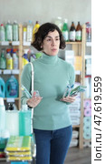 Positive middle-aged female customer choosing convenient toothbrush in large retail store. Стоковое видео, видеограф Яков Филимонов / Фотобанк Лори