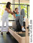 Positive activ hispanic female trainer controlling sports woman. Стоковое фото, фотограф Яков Филимонов / Фотобанк Лори
