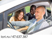 Cheerful man driving car with laughing friends. Стоковое фото, фотограф Яков Филимонов / Фотобанк Лори