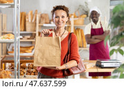 Woman showing paper bag with delicious pastries bought from bakery. Стоковое фото, фотограф Яков Филимонов / Фотобанк Лори