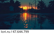 After the rain reflections: a golden sunset mirroring on the street after a summer shower. Стоковое AI-изображение, AI-художник Данила Большаков / Фотобанк Лори