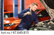 Male auto mechanic checking oil level in car engine in garage. Стоковое видео, видеограф Яков Филимонов / Фотобанк Лори
