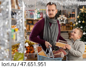 Young man with son choosing sweets at grocery store. Стоковое фото, фотограф Яков Филимонов / Фотобанк Лори