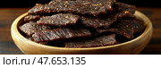 Appetizing close-up of bowl of beef jerky snacks: Ready to eat, ideal for outdoors adventures and healthy munching. Стоковое AI-изображение, AI-художник Данила Большаков / Фотобанк Лори