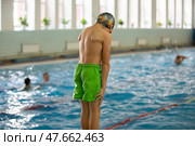 A boy in a swimming cap and goggles dives into a sports pool. Стоковое фото, фотограф Лазаренко Светлана / Фотобанк Лори