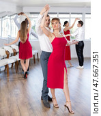 Woman in elegant red dress dancing waltz with partner during group class. Стоковое фото, фотограф Яков Филимонов / Фотобанк Лори