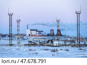 Зимний индустриальный пейзаж. Вид на башни и сооружения газоперекачивающей станции в заснеженной тундре. Вдали большая ТЭЦ. Промышленность северных регионов Сибири и Дальнего Востока России. Энергетика в Арктике. Чукотский автономный округ (Чукотка), Россия. Стоковое фото, фотограф Андрей Степанов / Фотобанк Лори