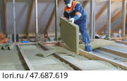 Insulation of a frame house with mineral wool. Cutting, fitting, laying insulation. Construction works. Стоковое видео, видеограф Константин Мерцалов / Фотобанк Лори
