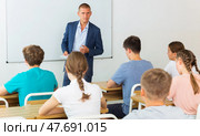 Male teacher lecturing to teenage students at auditorium. Стоковое фото, фотограф Яков Филимонов / Фотобанк Лори