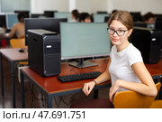 Clever female teenager wearing glasses and solving tasks of computer science in the auditory. Стоковое фото, фотограф Яков Филимонов / Фотобанк Лори