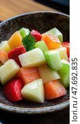 Fresh and vibrant fruit salad with melon, strawberry, and mint garnish. Стоковое AI-изображение, AI-художник ФотоИнтеллект / Фотобанк Лори