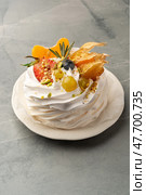 Delightful dessert served on a white plate with colorful fruit and cream topping in an elegant presentation. Стоковое фото, фотограф Сергей Толмачёв / Фотобанк Лори