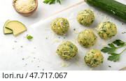 Homemade zucchini and herb dumplings prepared on a clean kitchen surface with fresh ingredients nearby. Стоковое AI-изображение, AI-художник Анна Сивакова / Фотобанк Лори
