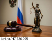 Символы правопорядка, Фемида с весами и молоток судьи, располагаются на столе в зале суда. Эта обстановка отражает важность справедливости в российском законодательстве. Стоковое AI-изображение, AI-художник Сергей Никифоров-Гордеев / Фотобанк Лори