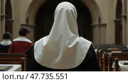 View from the back to the nun in the church, close-up. Стоковое AI-изображение, AI-художник Sergey Grishin / Фотобанк Лори