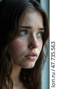 Tear-stained young woman sadly looks out the window. Стоковое AI-изображение, AI-художник Sergey Grishin / Фотобанк Лори