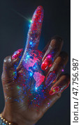 A hand decorated with vibrant colors and sparkles points upward, with a glowing map of the world prominent on the fingertip. Стоковое AI-изображение, AI-художник Данила Большаков / Фотобанк Лори