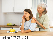 Elderly mother asks for forgiveness from her adult daughter and calms her down after a domestic quarrel in kitchen. Стоковое фото, фотограф Яков Филимонов / Фотобанк Лори