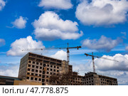 Construction Site Under a Clear Sky With Cranes and Scaffolding Working Tirelessly. Стоковое фото, фотограф Aleksandr Golubev / Фотобанк Лори