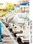 Boats docked at marina with white inflatables on sunny day. Стоковое фото, фотограф Анастасия Золотницкая / Фотобанк Лори