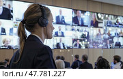 A focused female interpreter wearing headphones at a conference, translating speeches to facilitate multilingual communication. Стоковое AI-изображение, AI-художник Данила Большаков / Фотобанк Лори