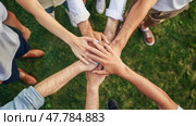 A group of diversified individuals standing in a circle, joining their hands together in unity and teamwork. Стоковое AI-изображение, AI-художник Данила Большаков / Фотобанк Лори