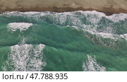 Ocean waves rolling over sandy coast, breaking white foam against turquoise waters, revealing natural power from aerial view with rhythmic water motion. Стоковое видео, видеограф ILIA GOROKHOV / Фотобанк Лори