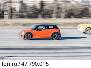 Orange Mini Cooper on road driving fast. Редакционное фото, фотограф Константин Григорьев / Фотобанк Лори