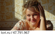 A Cheerful Young Woman Exuding Happiness is Sitting in a Sunlit Room, Softly Touching Her Hair While Smiling Warmly. Стоковое AI-изображение, AI-художник Sergey Grishin / Фотобанк Лори