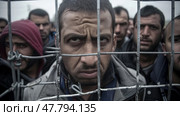 Several men are seen confined behind bars in a cage. Стоковое AI-изображение, AI-художник Данила Большаков / Фотобанк Лори