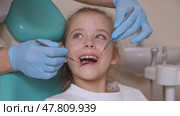 Close up dentist, doctor examines the oral cavity of a little girl, uses a mouth mirror, baby teeth close-up. Concept of pediatric dentistry, dental treatment. Slow motion footage. Стоковое видео, видеограф Ирина Михайличенко / Фотобанк Лори