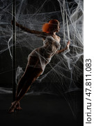 Red-haired woman entrapped in web-like net in dramatic lighting. Стоковое фото, фотограф Гурьянов Андрей / Фотобанк Лори