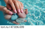 Hands holding colorful stones in a clear blue pool water. Руки с розовым маникюром держат разноцветные камни в прозрачной голубой воде бассейна. Стоковое AI-изображение, AI-художник Katsiaryna Repich / Фотобанк Лори
