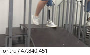 A woman with a modern robotic prosthetic leg is working out in the gym. Стоковое видео, видеограф Андрей Шалари / Фотобанк Лори