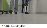 A disabled woman on a prosthesis walks next to a doctor in the clinic. Стоковое видео, видеограф Андрей Шалари / Фотобанк Лори