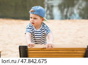 Summer lifestyle. A cute little boy is having fun playing in a modern outdoor playground. The concept of family entertainment and leisure. Стоковое фото, фотограф Photojuli / Фотобанк Лори
