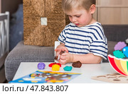 A little boy is playing with plasticine. Fine motor skills-developing games for children. The kid makes a horse. Useful games for child development. Стоковое фото, фотограф Photojuli / Фотобанк Лори