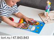A little boy is playing with plasticine. Fine motor skills-developing games for children. The kid makes a horse. Useful games for child development. Стоковое фото, фотограф Photojuli / Фотобанк Лори