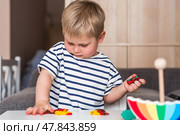 A little boy is playing with plasticine. Fine motor skills-developing games for children. The kid makes a horse. Useful games for child development. Стоковое фото, фотограф Photojuli / Фотобанк Лори