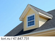 House Exterior. Roof Window. Second floor among blue sky. Mansard attic. Newly build houses. Gable roof with skylight, asphalt roofing, shingles. Residential Home. Vinyl Siding. Polymeric roof-tiles. Стоковое AI-изображение, AI-художник Марина Демидюк / Фотобанк Лори