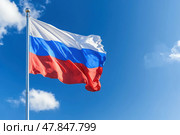 Российский флаг. Трёхцветный российский флаг развивается на фоне голубого неба. Стоковое AI-изображение, AI-художник Башкирова Анна / Фотобанк Лори