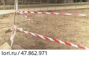Red and white caution tape blowing in the wind on a construction site. Стоковое видео, видеограф Андрей Знаменский / Фотобанк Лори